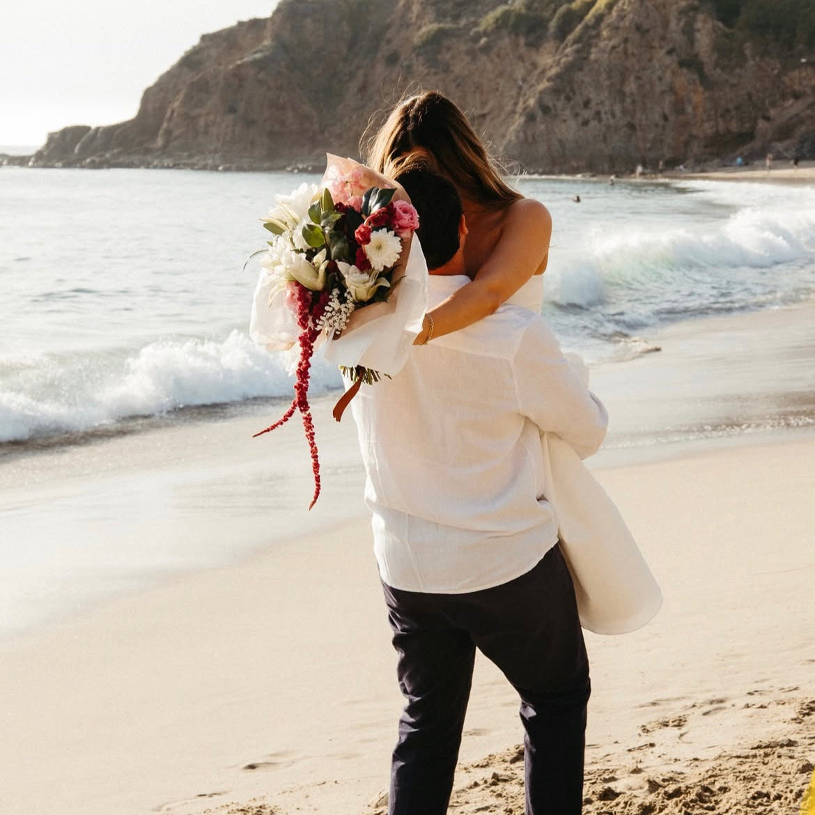 Alex and Grace embraced after proposing to each other at the beach