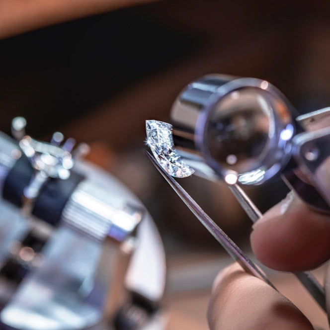 Jewelry quality inspection using magnifying glass and professional instruments to check diamond stability, clarity, color, and ring finish