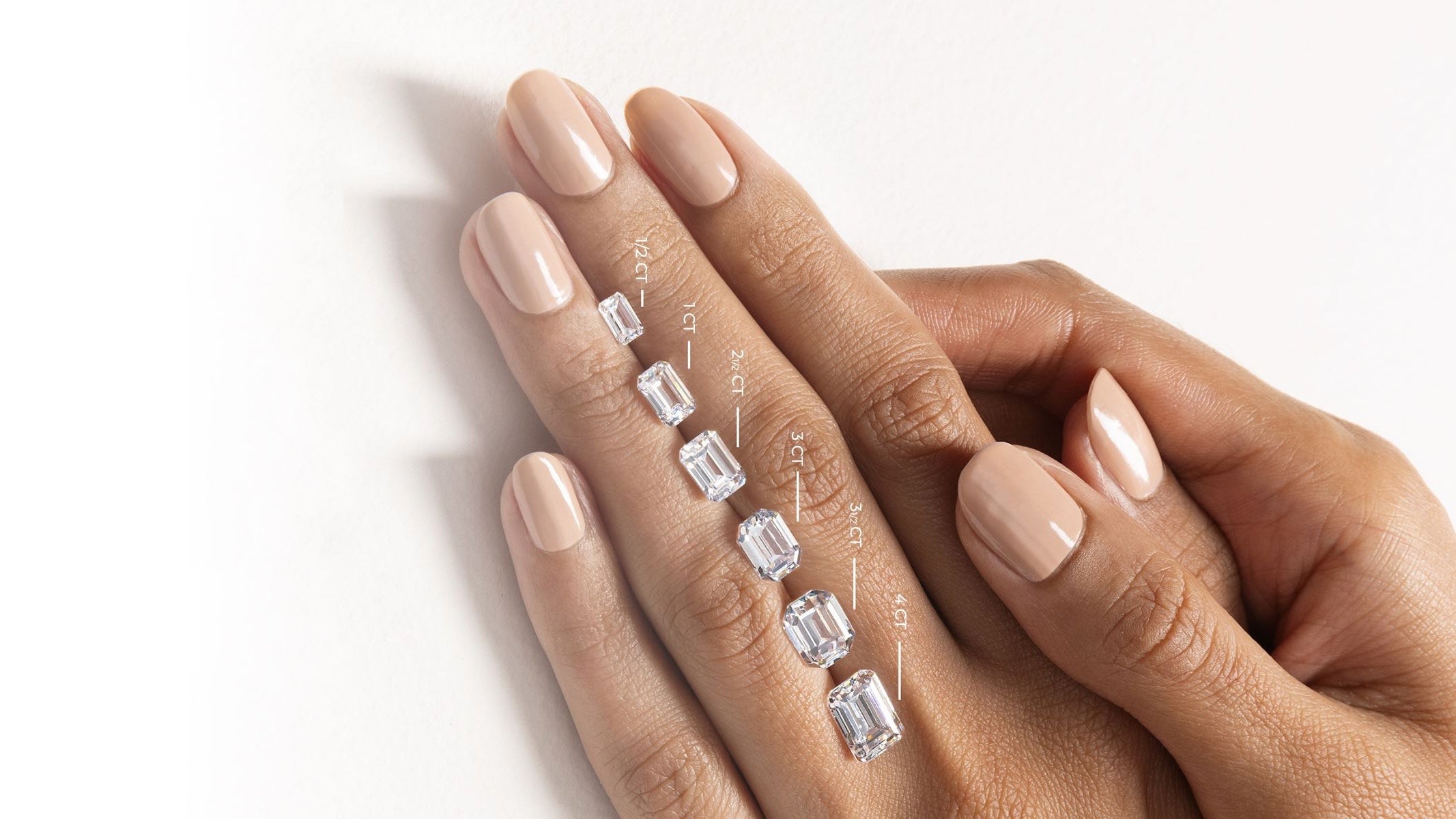 Display of different carat diamond sizes on hand